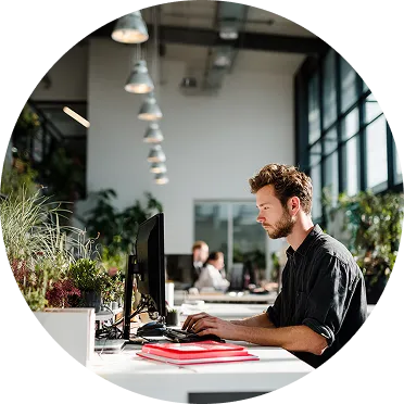 młody mężczyzna siedzi przy biurku w biurze