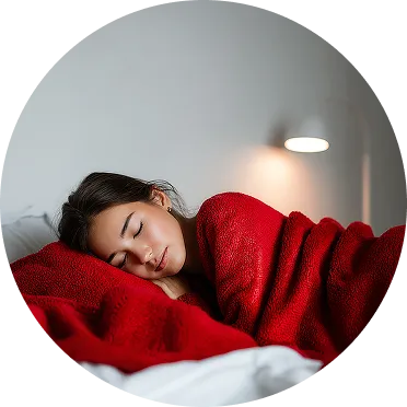 młoda kobieta śpi w łóżku pod czerwonym kocem